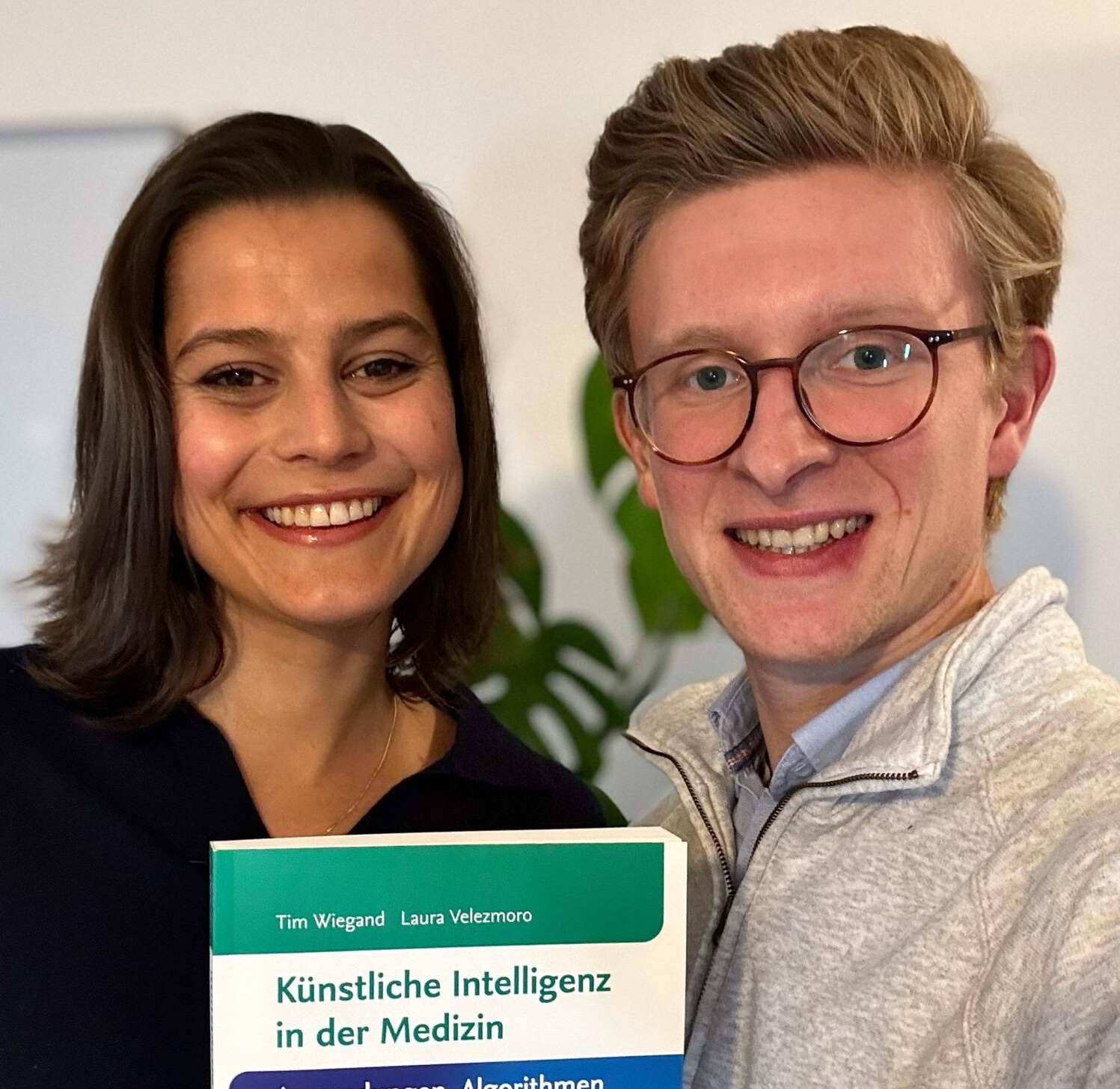 Tim Wiegand and Laura Velezmoro holding their book Künstliche Intelligenz in der Medizin